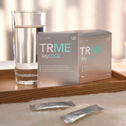 TRME MyEDGE supplement packages with a glass of water on a wooden surface.