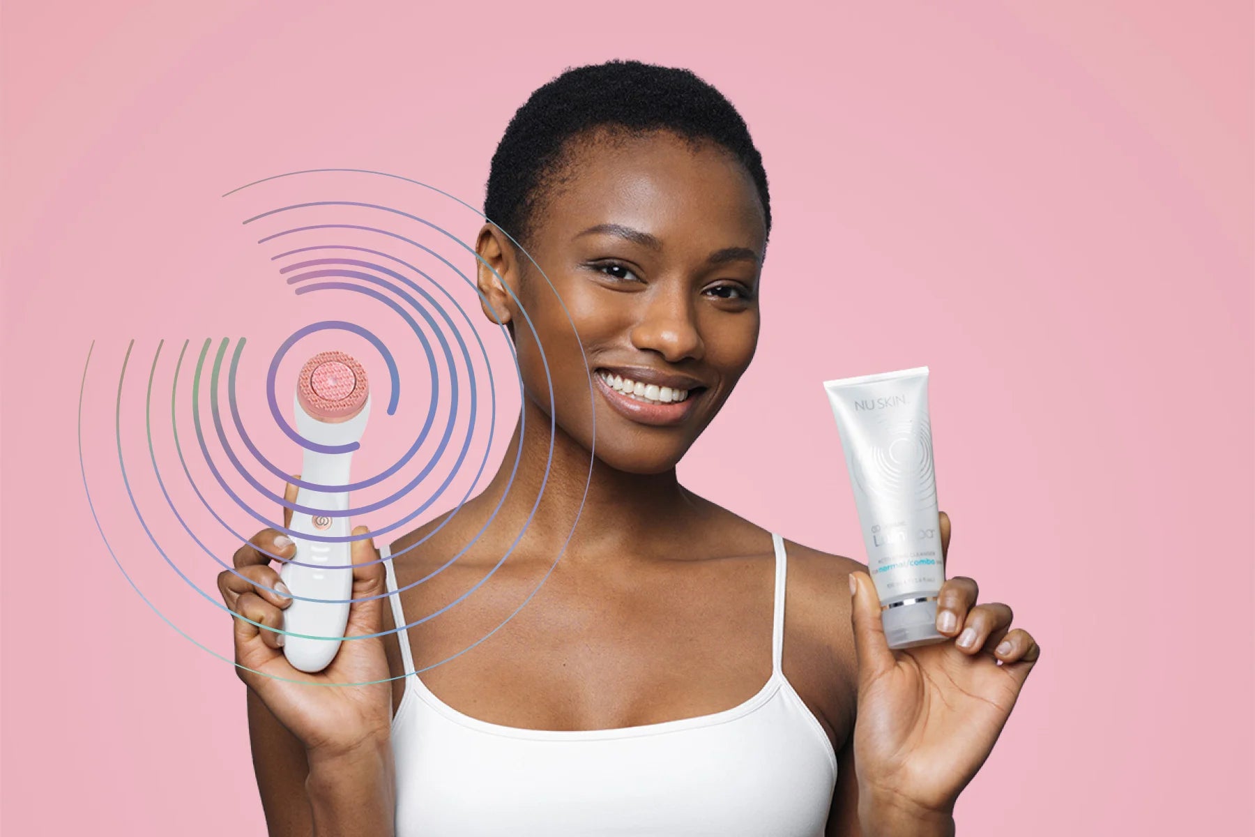 Woman holding the rose gold lumispa and cleanser