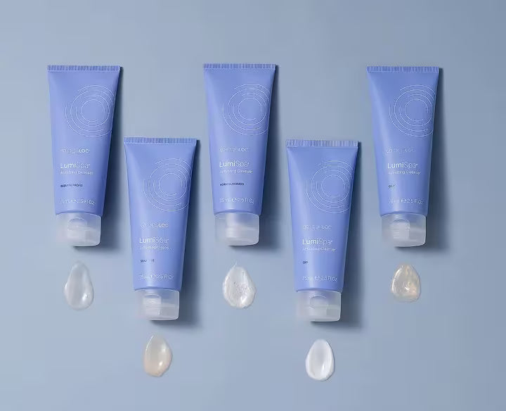 Set of blue lumispa cleansers with droplets on a matching blue background