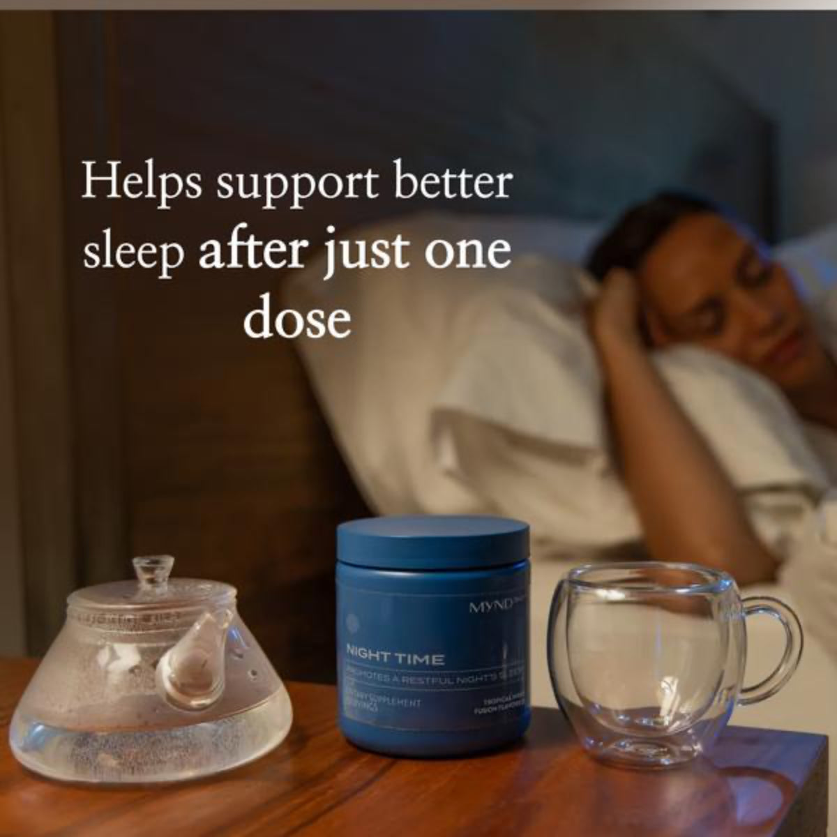 Blue container labeled 'NIGHT TIME' on a table with a teapot and glass mug, with text about sleep support.