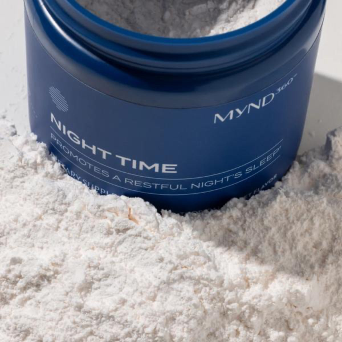 Blue container labeled 'MYND360 Night Time' surrounded by white powder on a light background