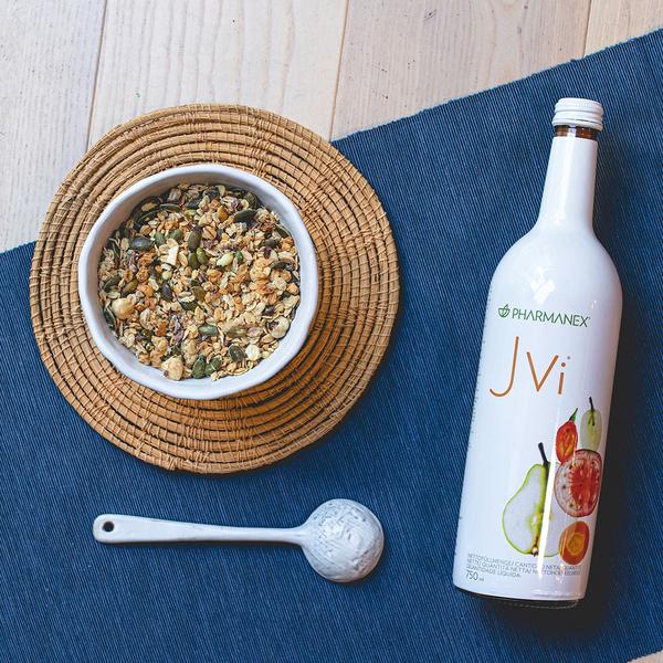 Bowl of granola, spoon, and Jvi bottle on a blue mat