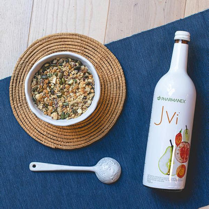 Bowl of granola, spoon, and Jvi bottle on a blue mat