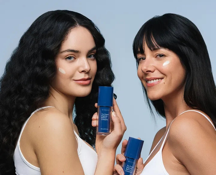 Two women holding 2 women using ageLOC retinol products against a light blue background